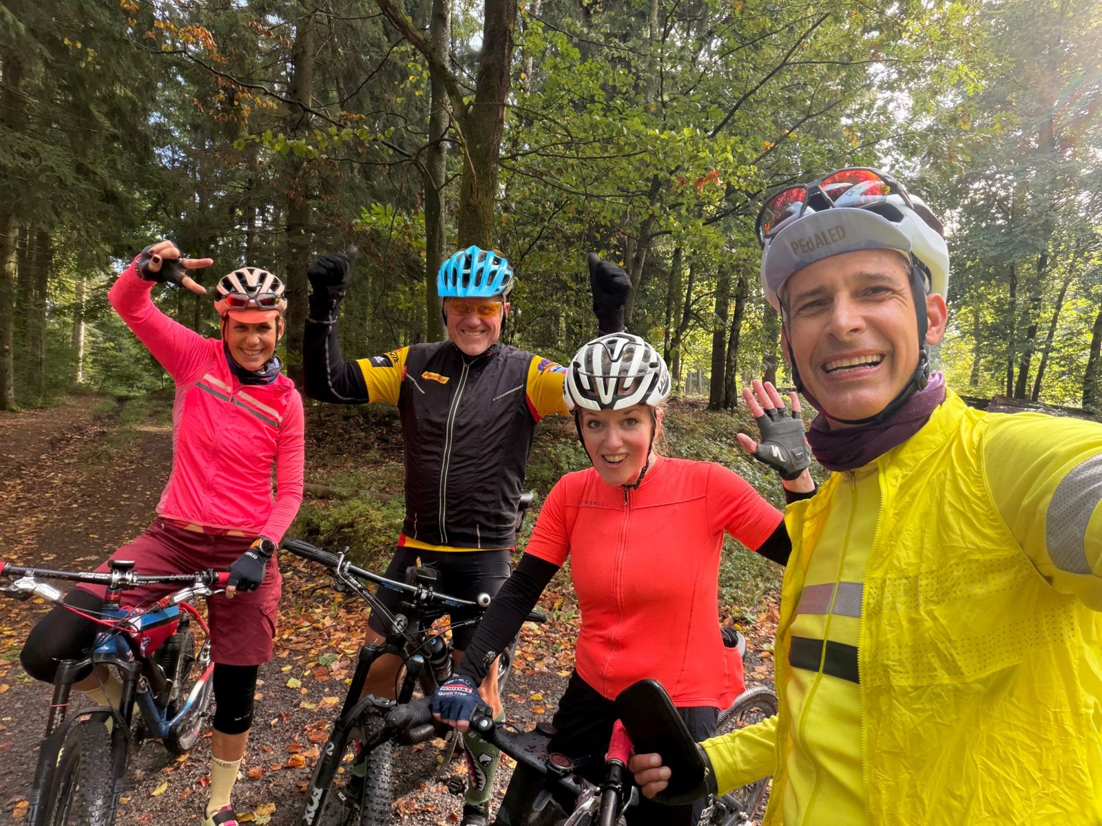 Vier Radfahrer im Wald, alle gut gelaunt